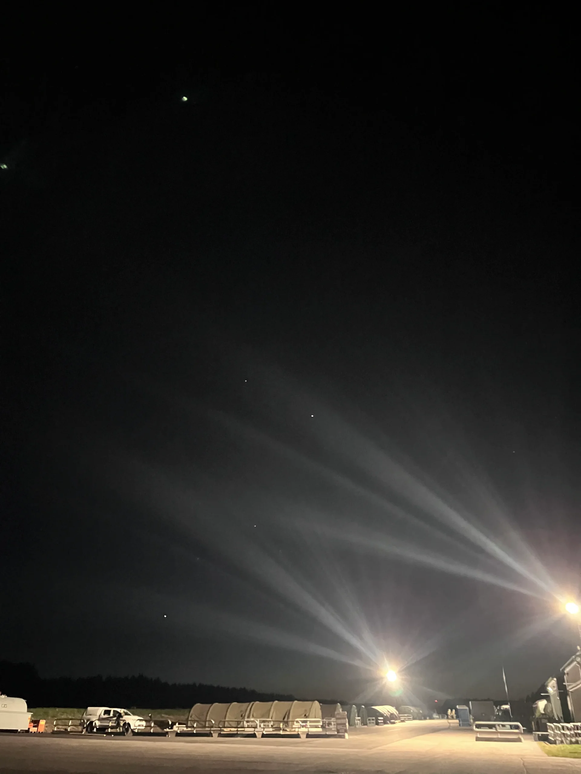 Nattlig himmel över ett upplyst fält