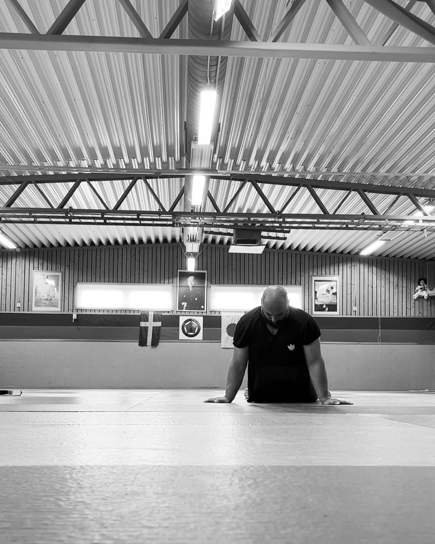 Jim Nano sitter på mattan i en tom dojo